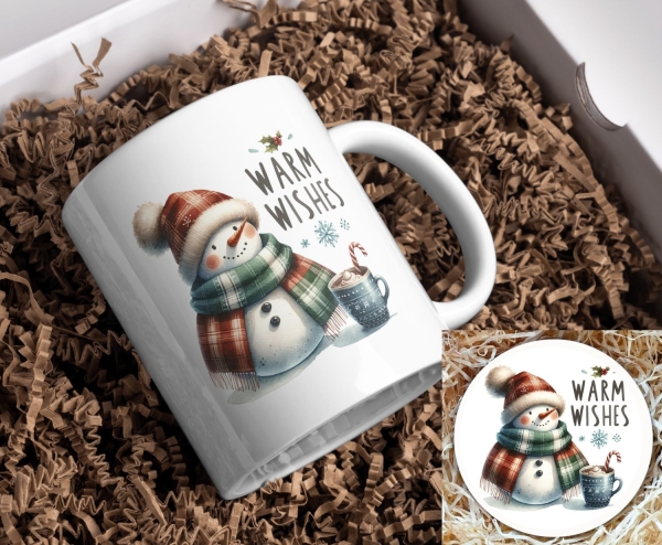 Weihnachtstasse mit Schneemann und ‚Warm Wishes‘-Motiv sowie passendem Untersetzer: Ein gemütlicher Schneemann mit rot-grün kariertem Schal und roter Mütze hält eine Tasse heißen Kakao mit Zuckerstange. Über dem Motiv steht der Schriftzug ‚Warm Wishes‘ ve